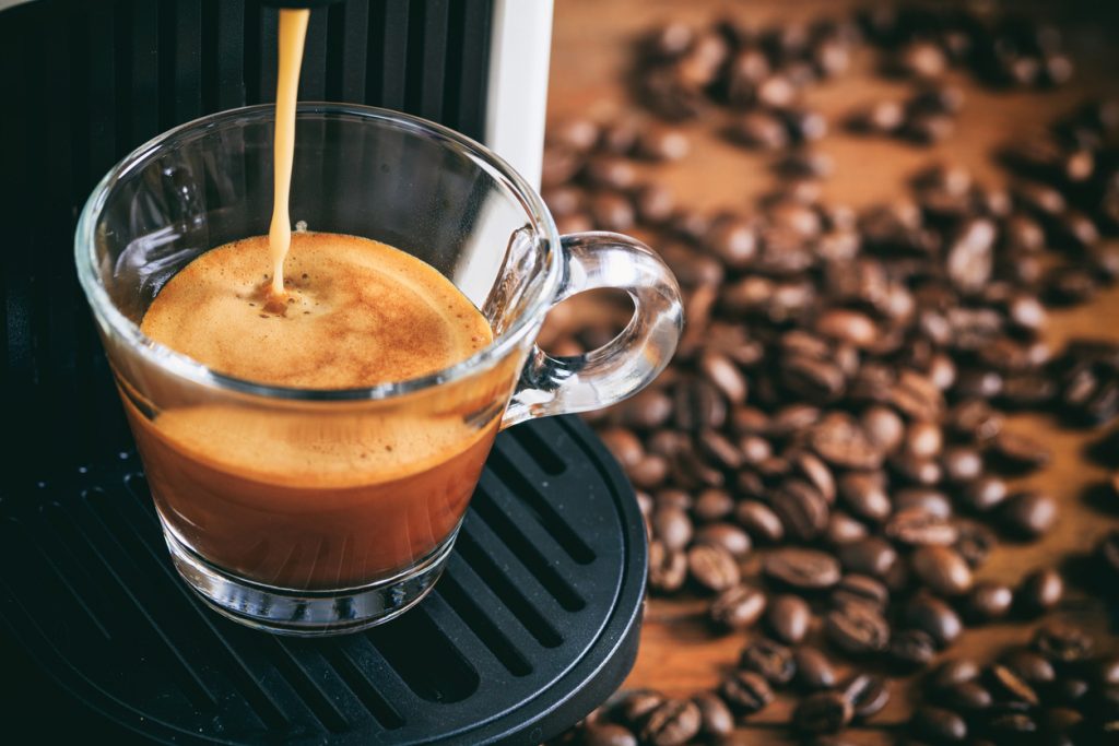 káva tečie z kávovaru do skleného pohára