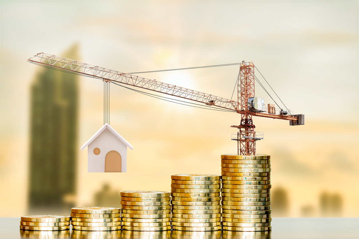 Stacking gold coin with increase and tower crane and hoist brake solutions with build new house on photo blur cityscape background, saving money and loan for construction real estate and home concept.