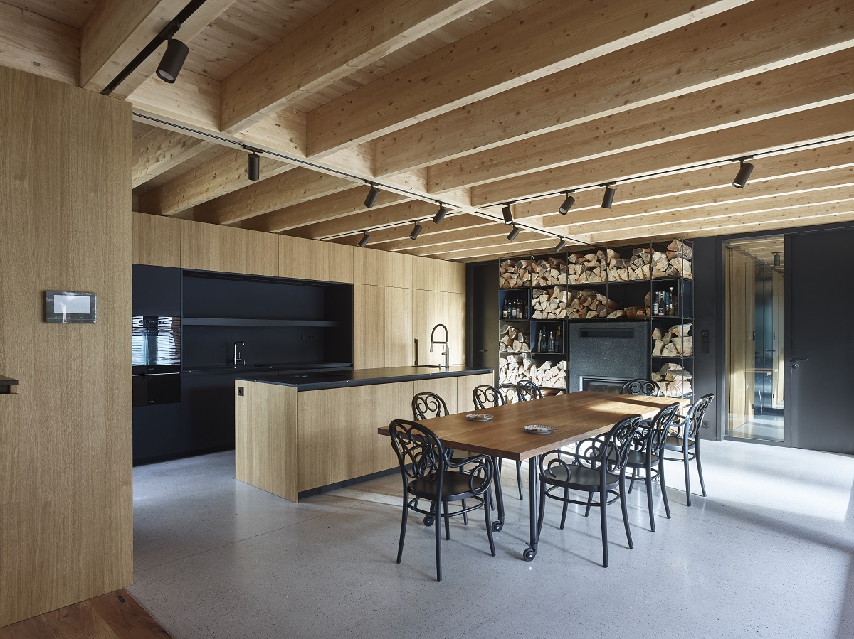 interiér s dreveným stropom, jedálenským stolom a čiernymi stoličkami