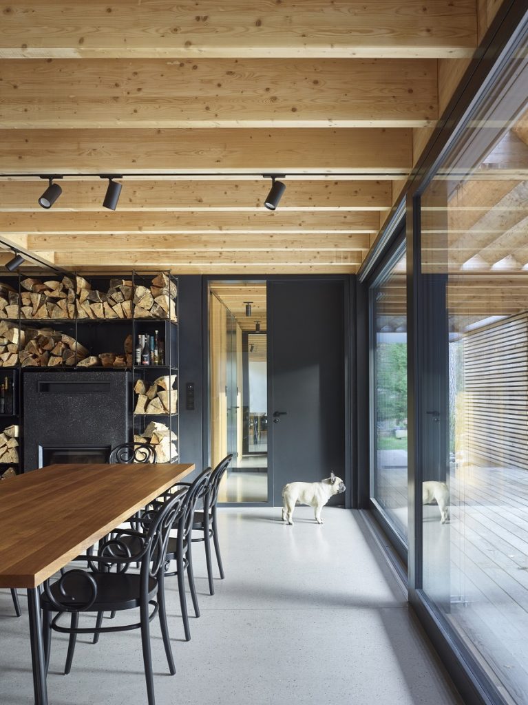 interiér s dreveným stropom, jedálenským stolom a čiernymi stoličkami