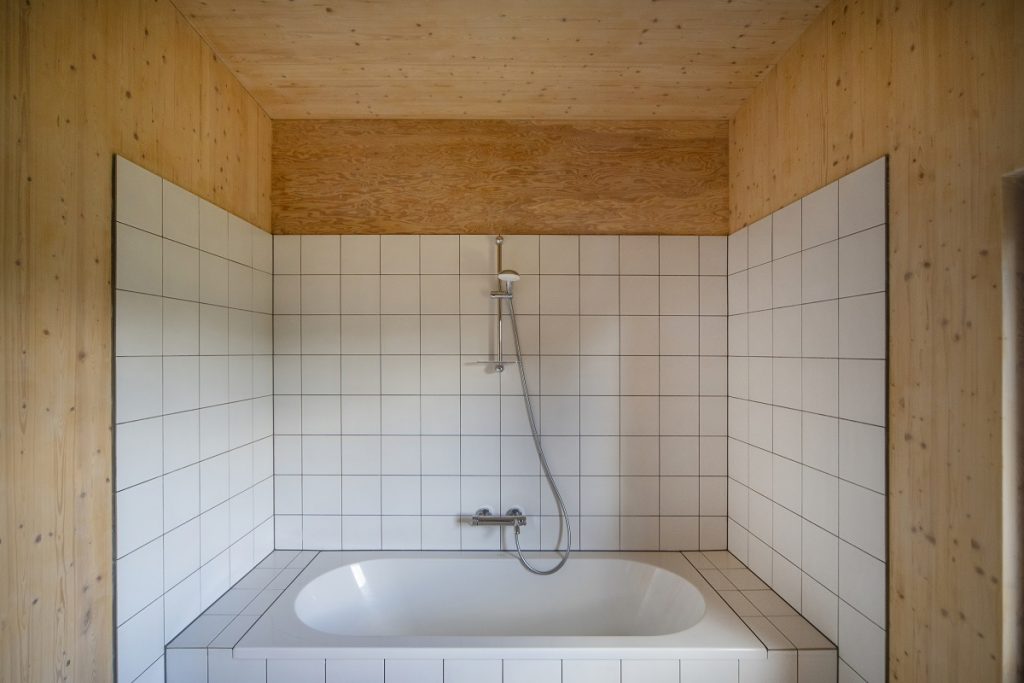 kúpeľňa obložená drevom a bielymi obkladačkami