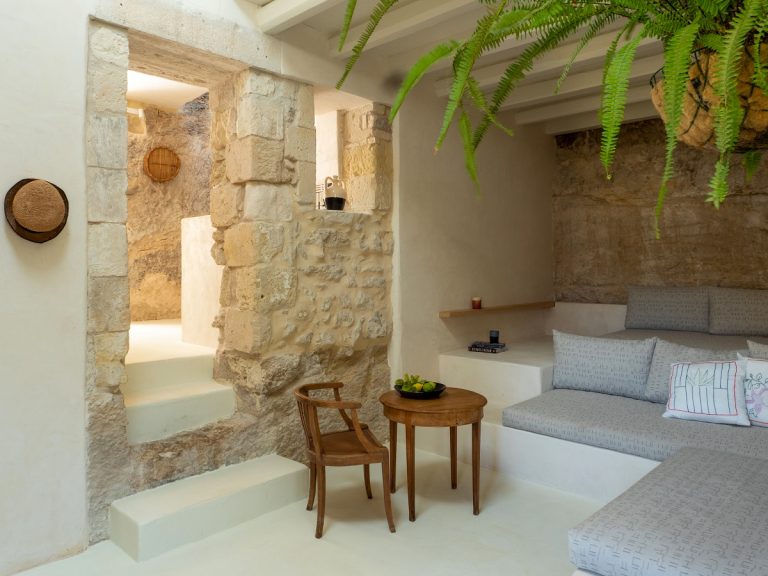 obývačka s kamennými stenami a svetlým nábytkom
