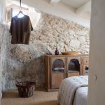 spálňa s kamennou stenou a vintage nábytkom
