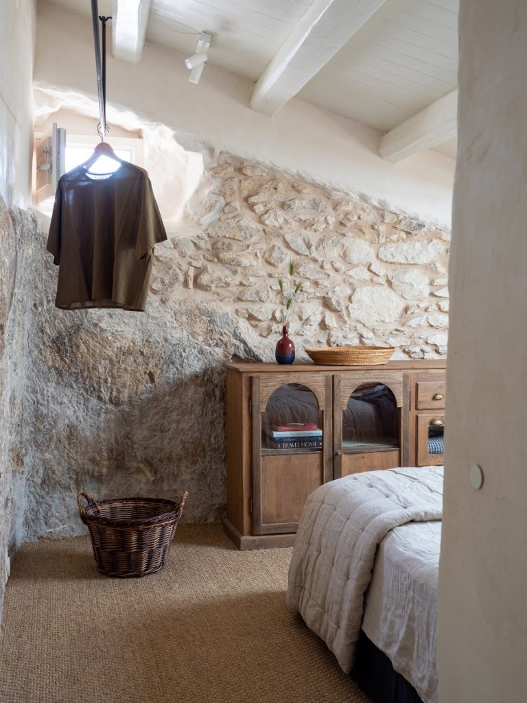 spálňa s kamennou stenou a vintage nábytkom
