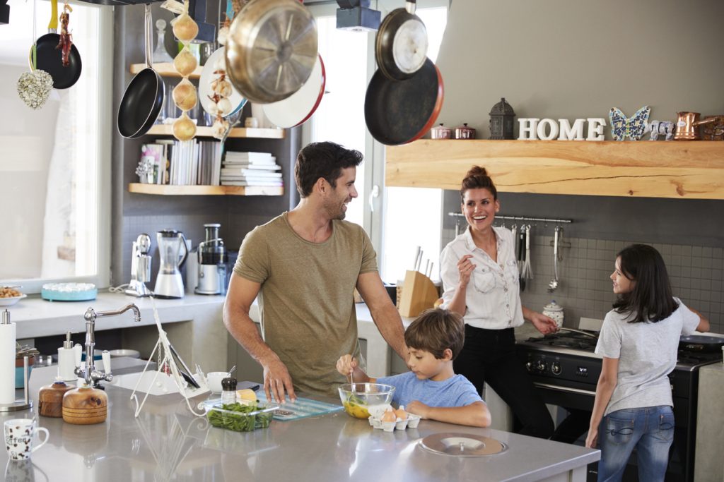 Family In Kitchen Making Morning Breakfast Together