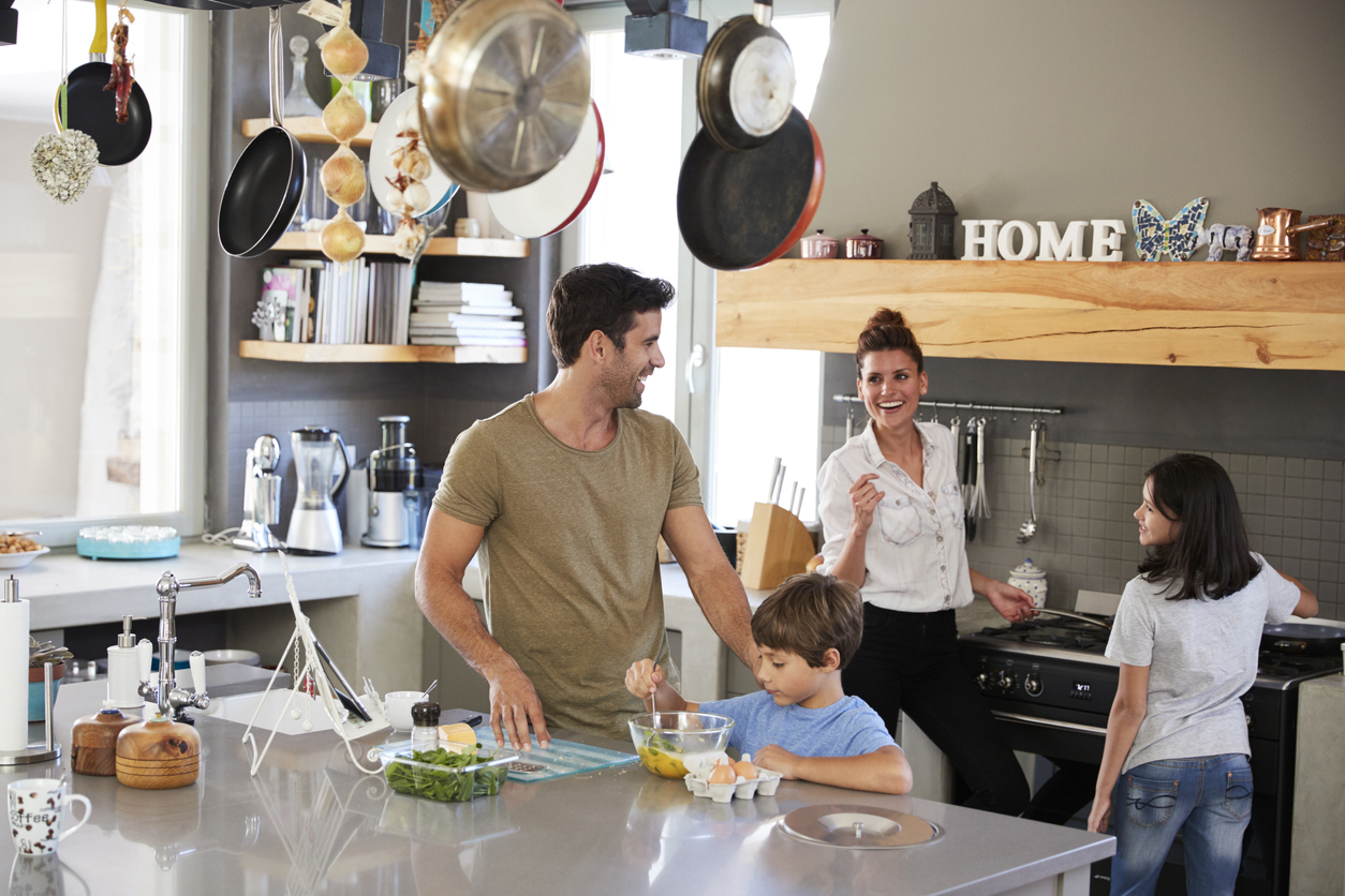 Family In Kitchen Making Morning Breakfast Together