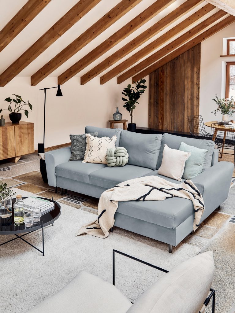 obývačka so sivou sedačkou a trámovým stropom