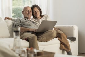 muž a žena na bielej pohovke s počítačom