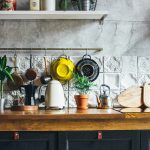 kuchynské náčinie zavesené na stene, cedidlo, doska na krájanie, bylinky, vintage kuchyňa