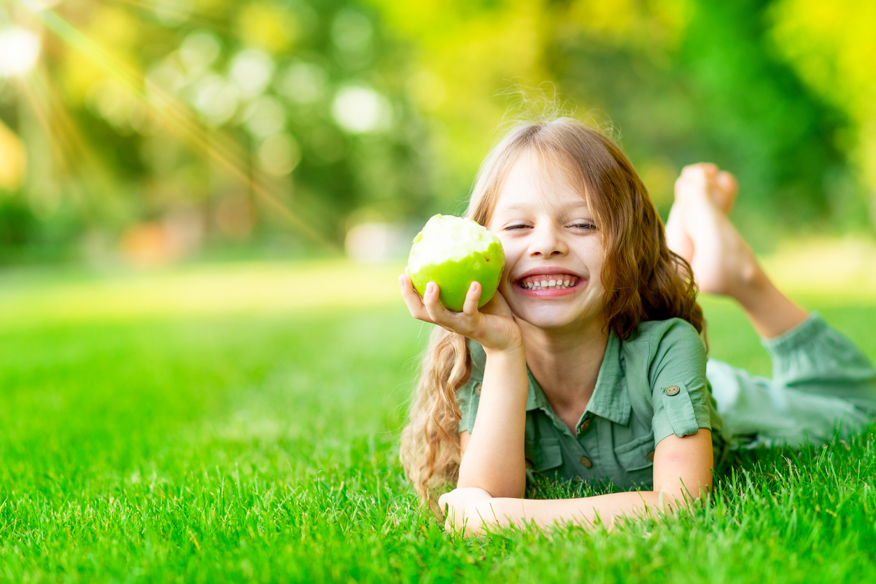 dievčatko s ovocím na trávniku