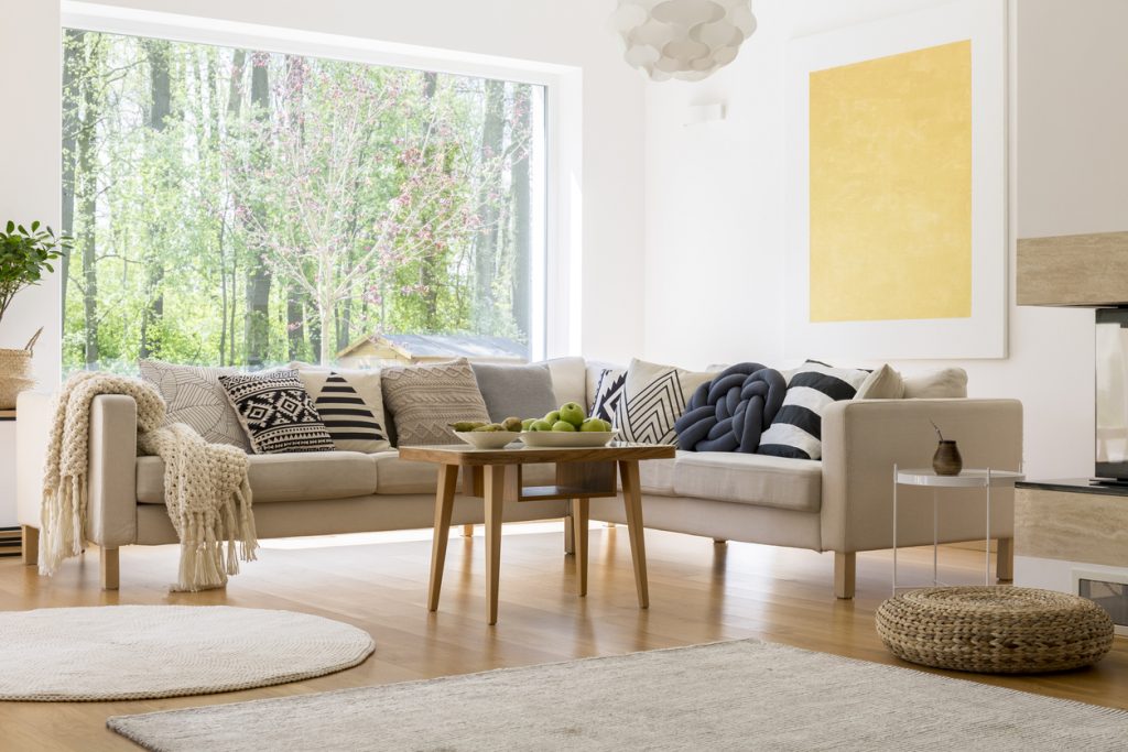 obývačka s bledou sedačkou a farebnými vankúšmi