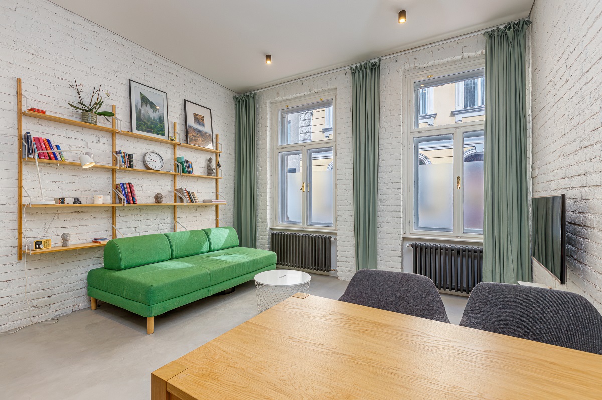 obývačka s veľkými oknami a zelenou sedačkou