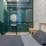 spálňa s tehlovou stenou a tyrkysovo zelenou kúpeľňou