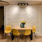 lamelový strop v miestnosti so žltými stoličkami okolo stola