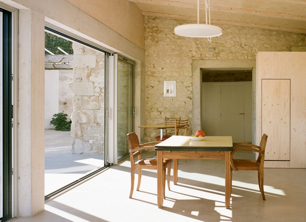 masívny rustikálny drevený stôl v izbe s kamennými stenami