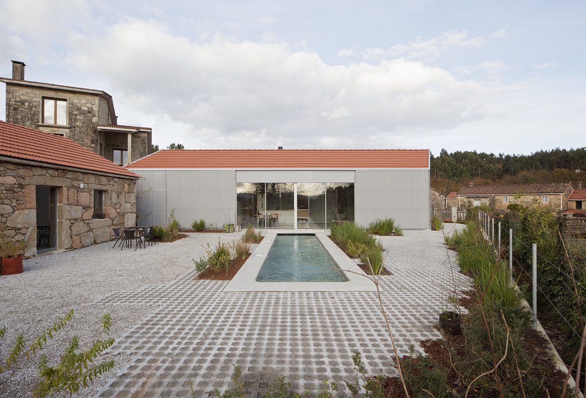 moderný a tradičný kamenný dom vedľa seba, v strede bazén