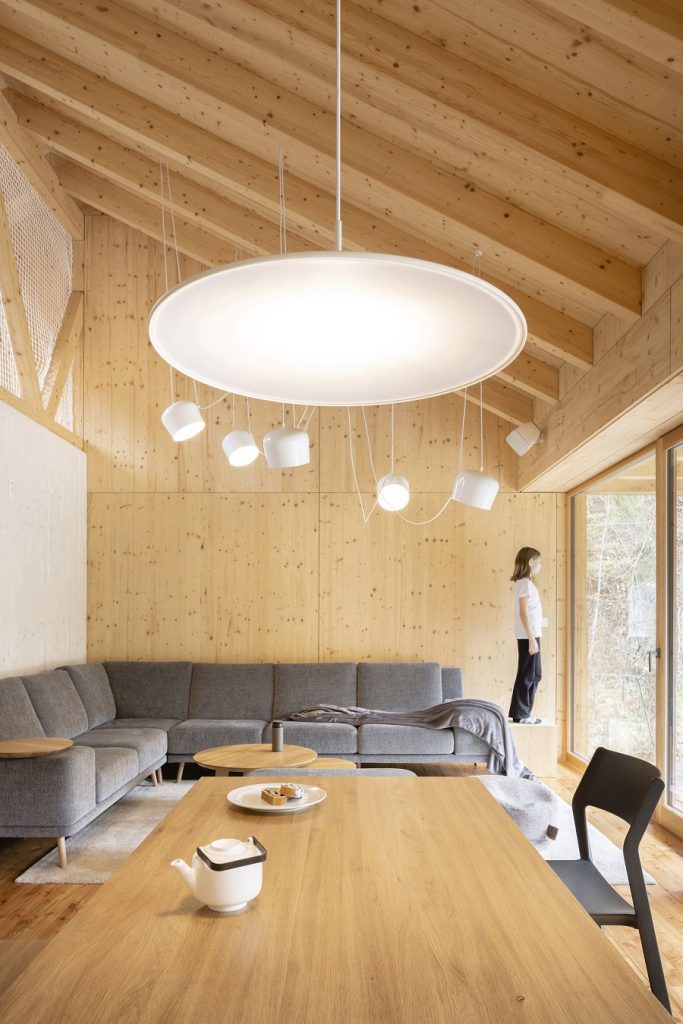 obývačka so sivou sedačkou v drevenej chate