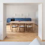 kuchyňa s parketovou podlahou a modrou kuchynskou linkou, stôl, stoličky