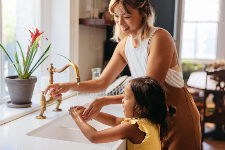 mama a dcéra si umývajú ruky pri umývadle s retro batériou