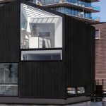 Plávajúci dom v tvare skosenej čiernej kocky v Amsterdame