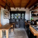 Interiér drevodomu so starožitným kredencom, kuchynskou linkou a jedálenským stolom
