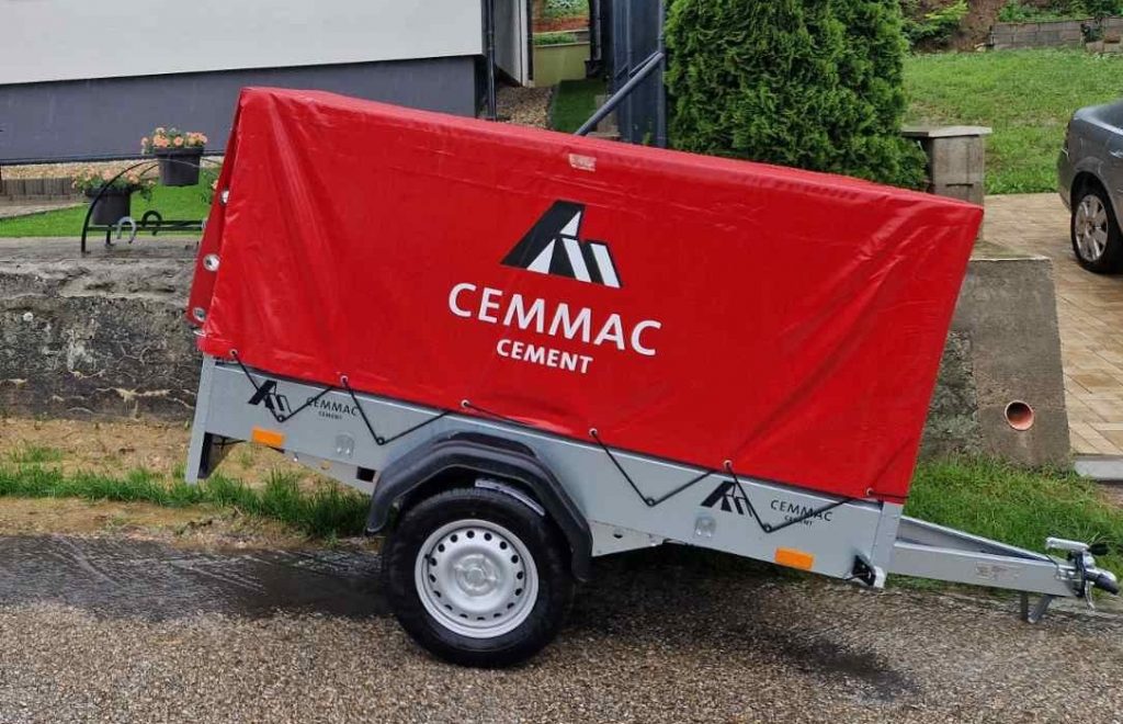 Prívesných vozík od firmy Cemmac s červenou plachtou.
