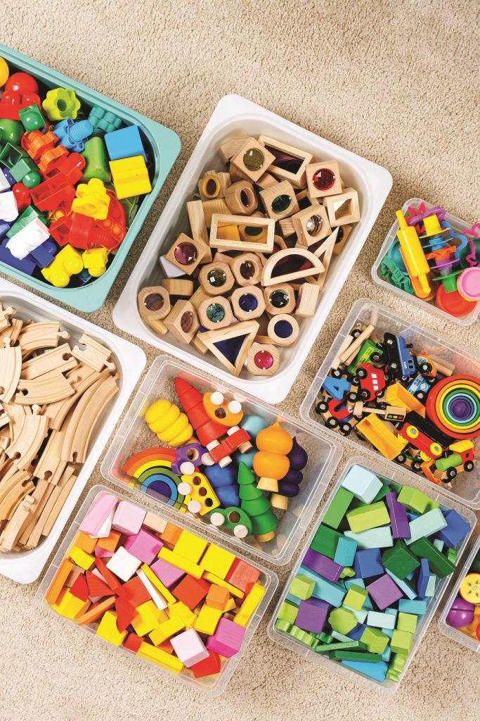 Plastové boxy rozličných veľkostí, plné hračiek a stavebníc.