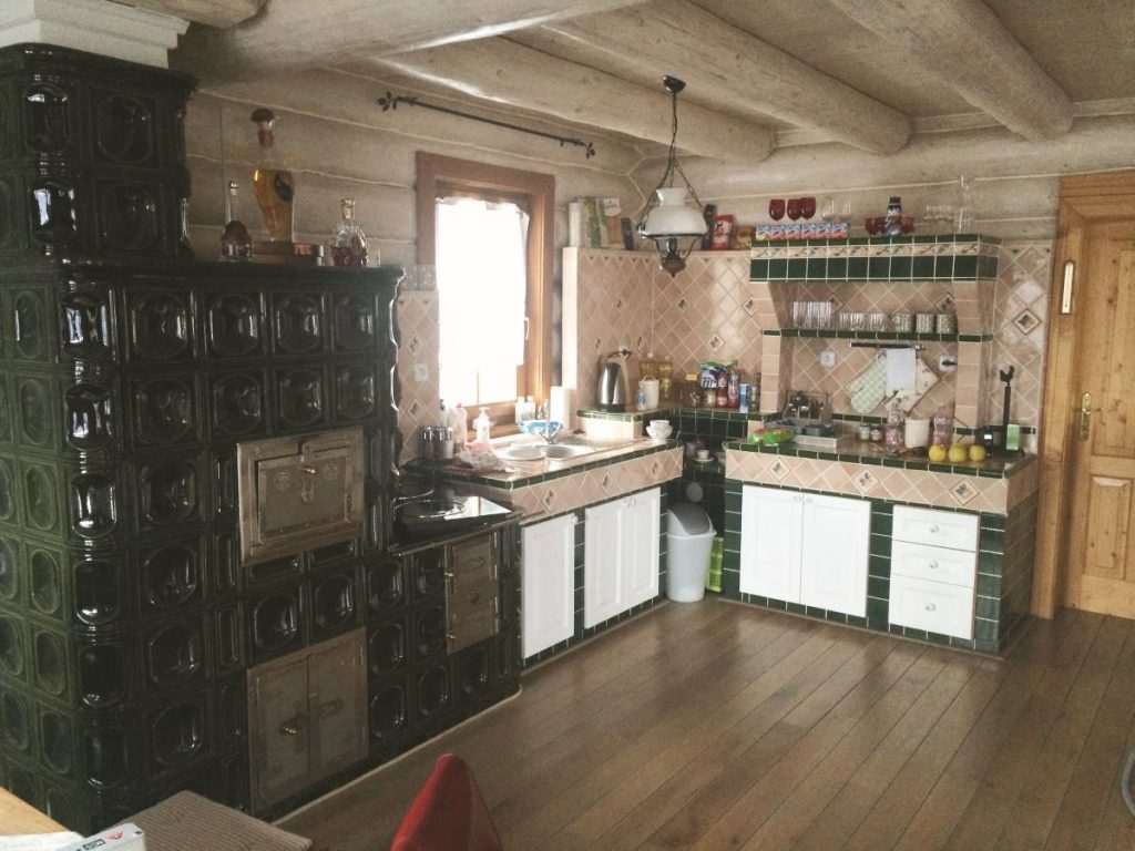 Pôvodná murovaná kuchyňa so zelenou pecou.