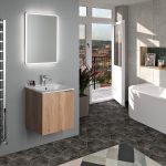Kúpeľňa s umývadlom na stene, podsvieteným obdĺžnikovým zrkadlom a vaňou pri stene s nikou, slúžiacou ako polička.