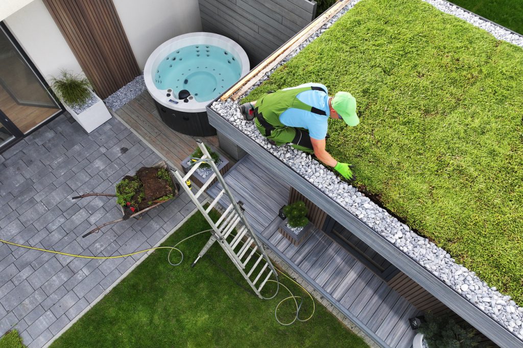 Pracovník vytvára zelenú strechu.