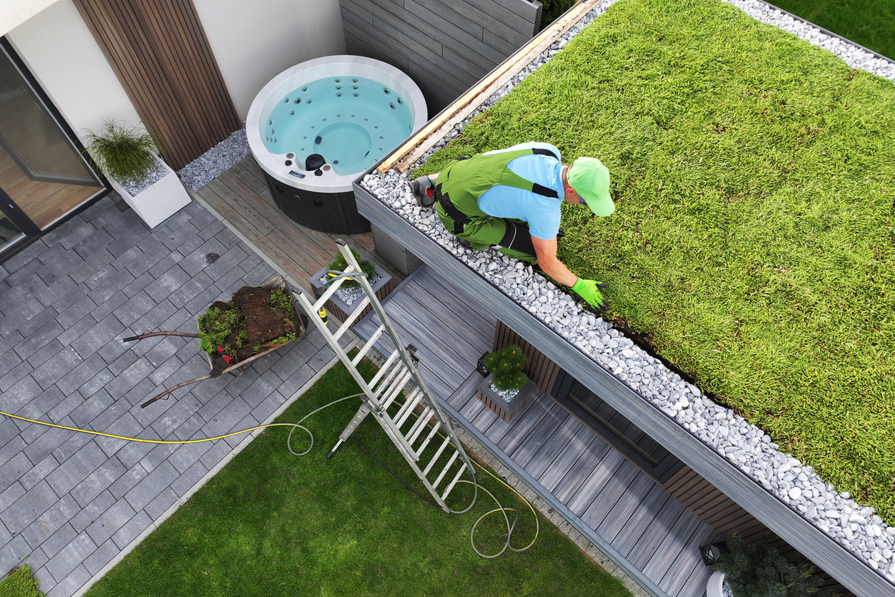 Pracovník vytvára zelenú strechu.