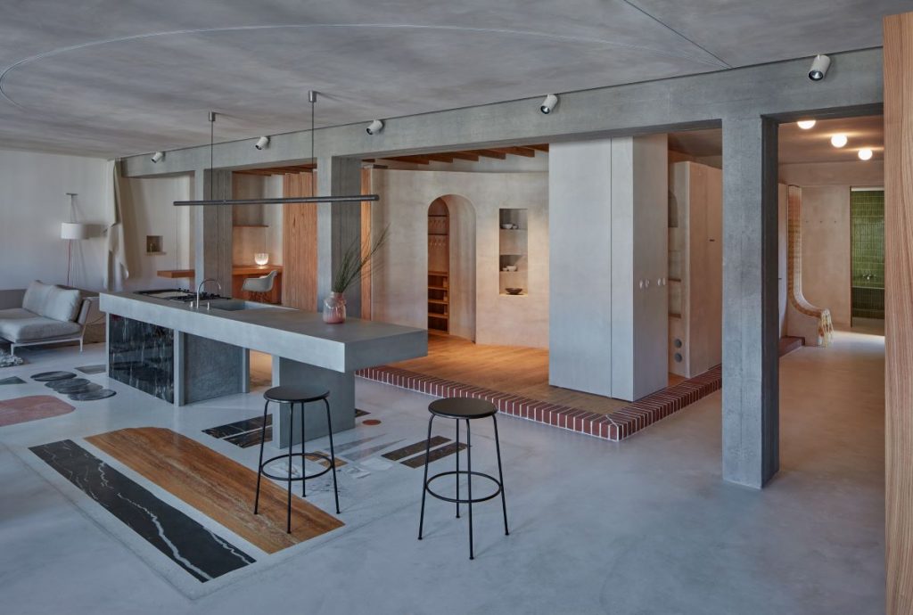 Kuchyňa s betónovým kuchynským ostrovčekom a terazzo podlaha s motívom obrazu.