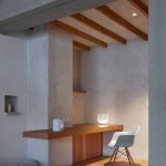 Drevený stôl zabudovaný medzi stenu a stĺp v rohu kuchyne.