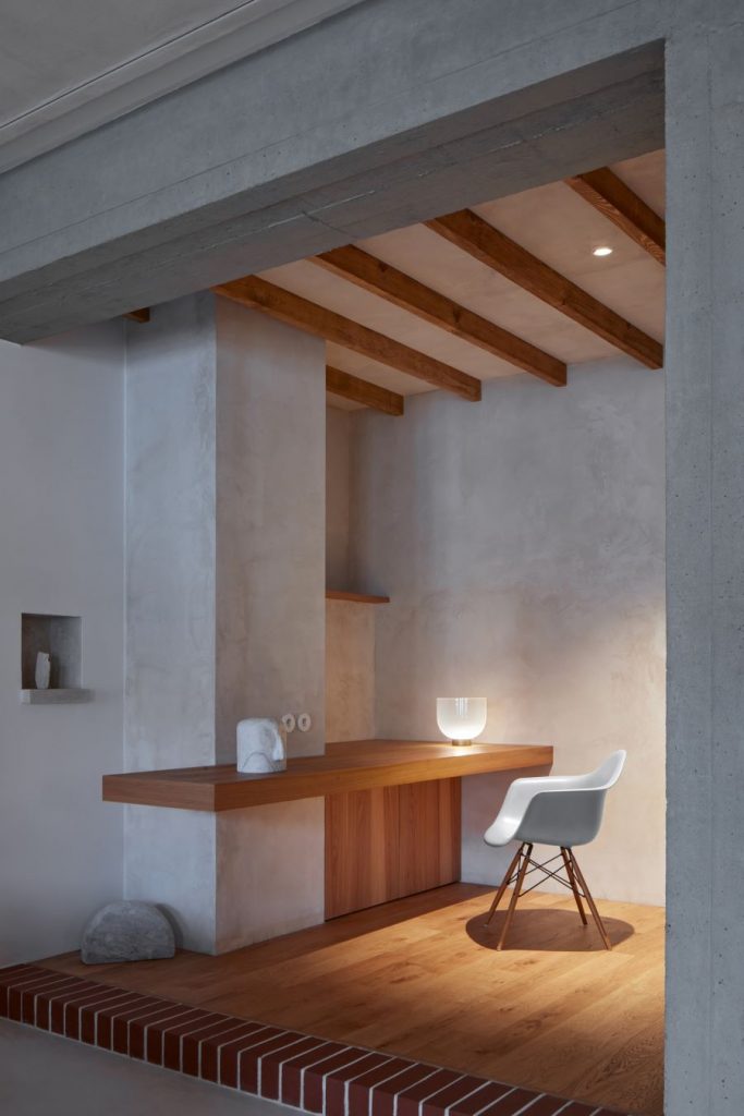 Drevený stôl zabudovaný medzi stenu a stĺp v rohu kuchyne.