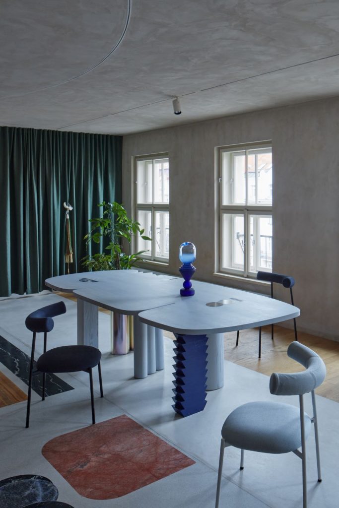 Umelecky tvarovaný jedálenský stôl s tromi dizajnovými stoličkami.
