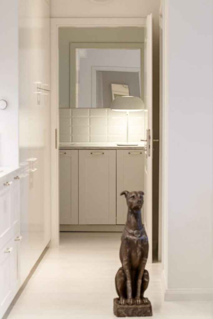 Socha sediaceho psa v chodbičke smerujúcej zo spoločenskej miestnosti do kúpeľne.