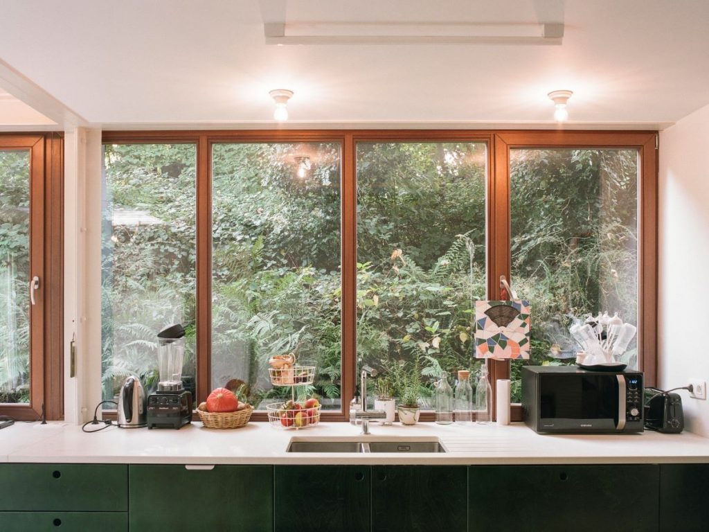 Pás okien zboku domu, ktorý presvetľuje kuchyňu.