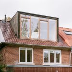 Exteriér domu v Bruseli s veľkoformátovými oknami vo vikieri na streche.