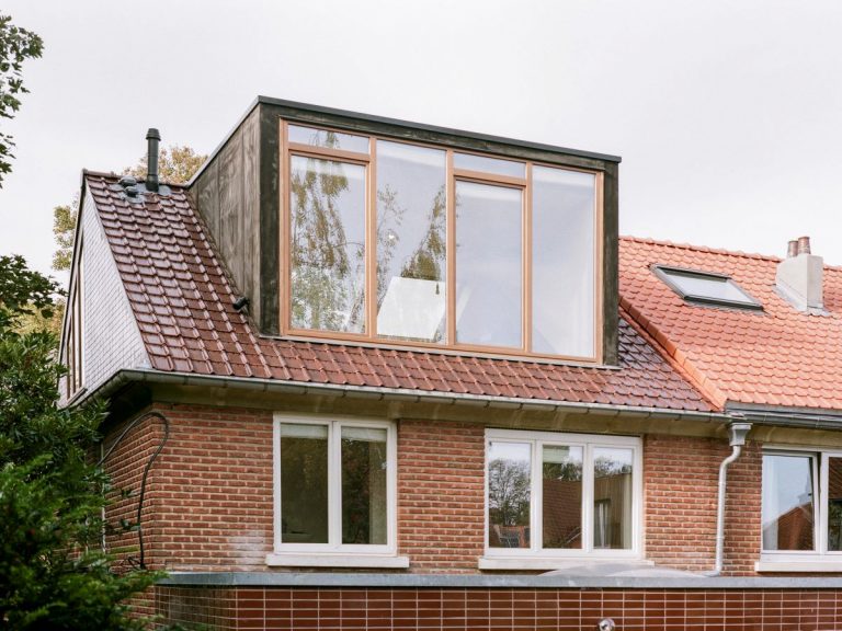 Exteriér domu v Bruseli s veľkoformátovými oknami vo vikieri na streche.