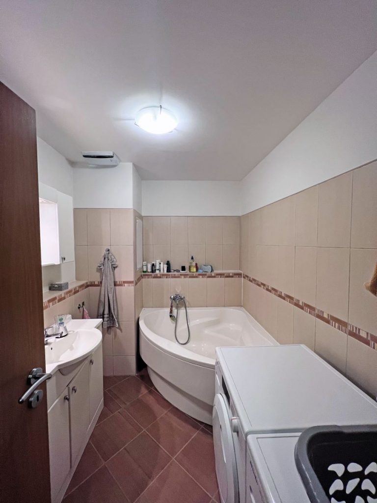 Kúpeľňa s rohovou vaňou, práčkou a umývadlom pred premenou.