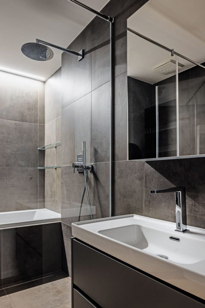 Moderne zariadená kúpeľňa so sprchovacím kútom a uymývadlom.