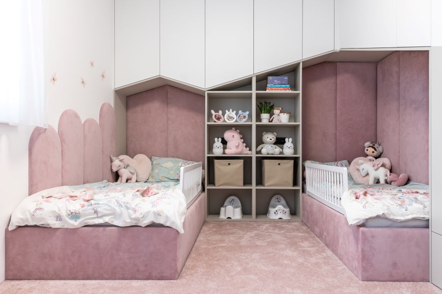 Dievčenská izba s dvoma posteľami a hračkami.