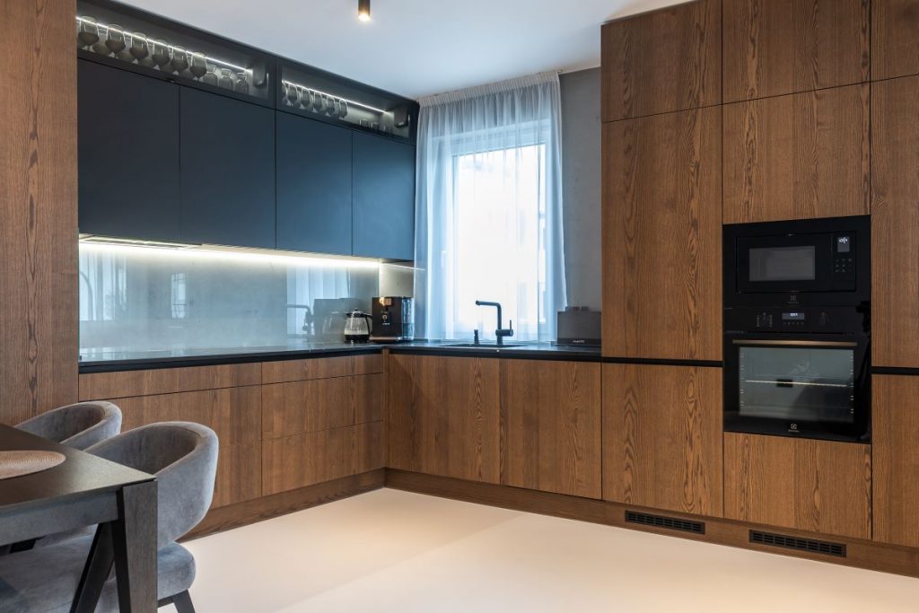 Moderná kuchyňa s kuchynskou linkou v kombinácii dreva a čiernej farby.