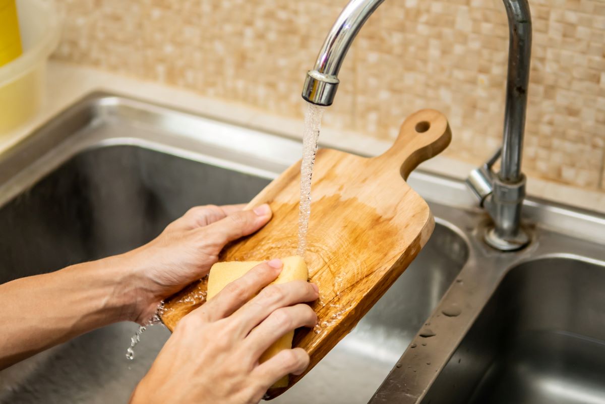 Umývanie drevenej dosky vodou a saponátom.