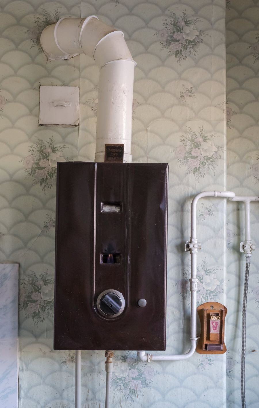 Starý plynový boiler na stene.