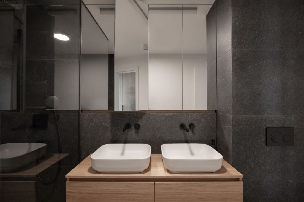 Pohľad na časť kúpeľne s dvoma umývadlami a zrkadlom v kúpeľni.