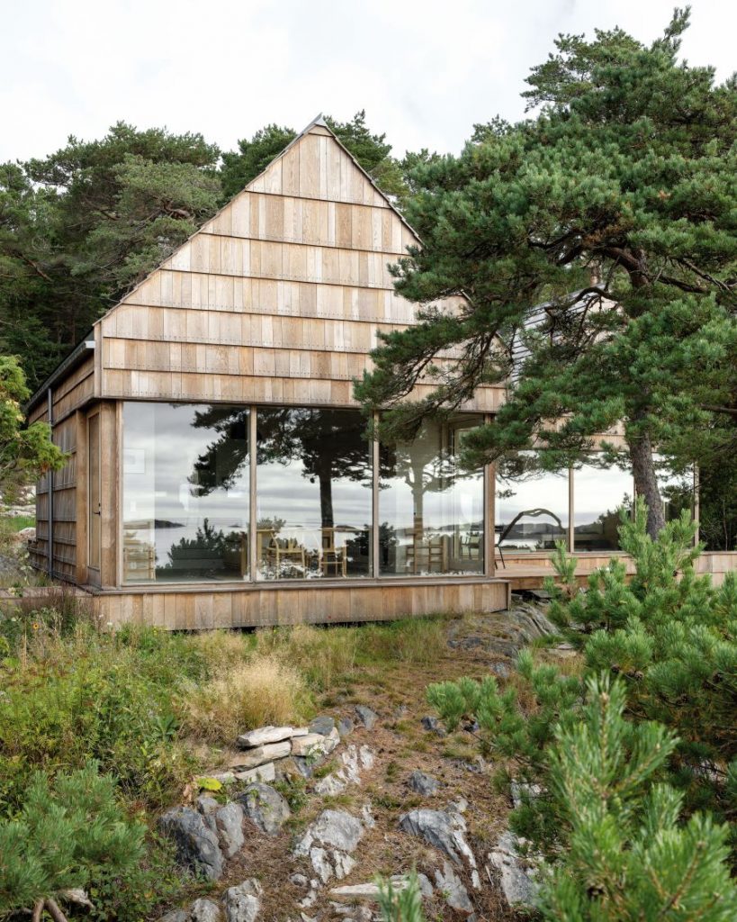 Exteriér ekodomu Saltviga House v Nórsku s drevenou fasádou a zeleňou.