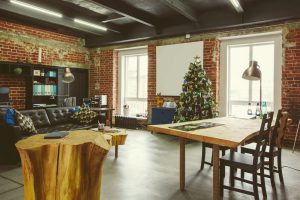 Obývačka s jedálňou a vianočným stromčekom, zariadená v industriálnom štýle.