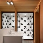 Kúpeľňa s hexagónovým čierno-bielym obložením v sprchovacom kúte.