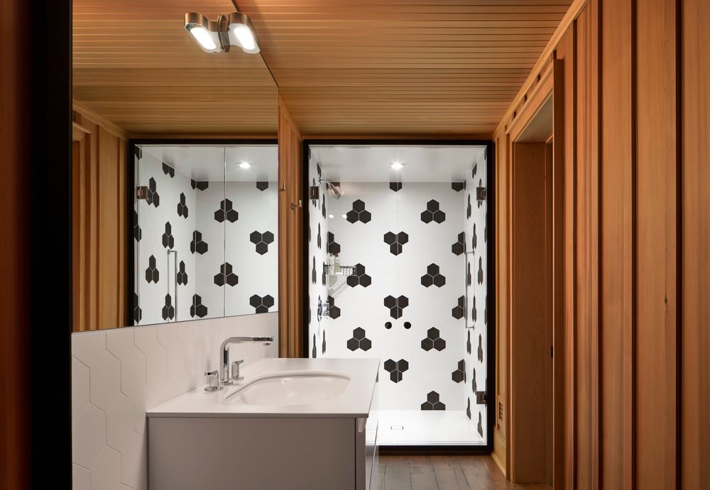 Kúpeľňa s hexagónovým čierno-bielym obložením v sprchovacom kúte.